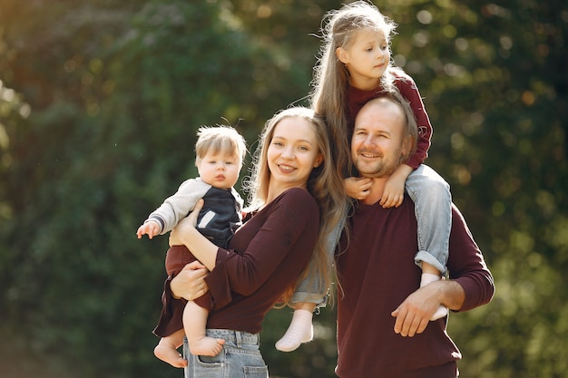 Famiglia con bambini carini in un parco in autunno