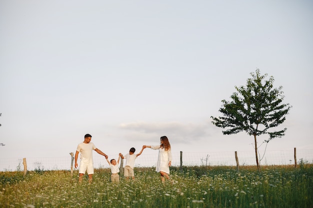 Famiglia con bambino piccolo carino. Padre con una maglietta bianca. Sfondo tramonto.