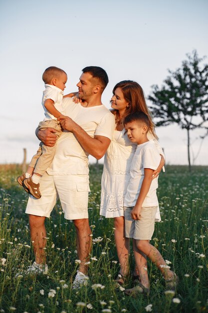 Famiglia con bambino piccolo carino. Padre con una maglietta bianca. Sfondo tramonto.