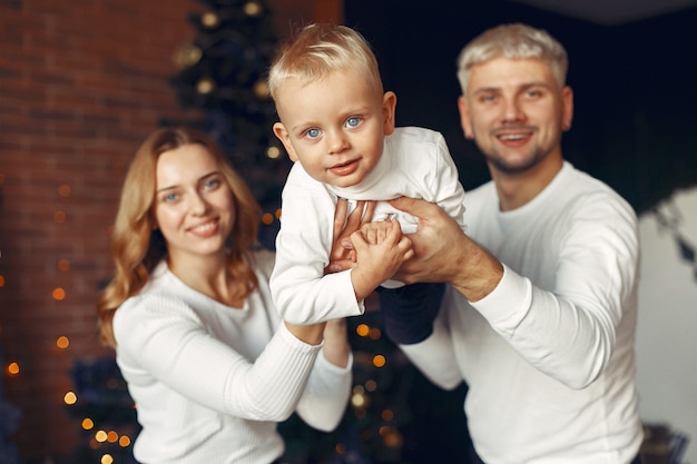 Famiglia con figlio piccolo a casa vicino all'albero di Natale