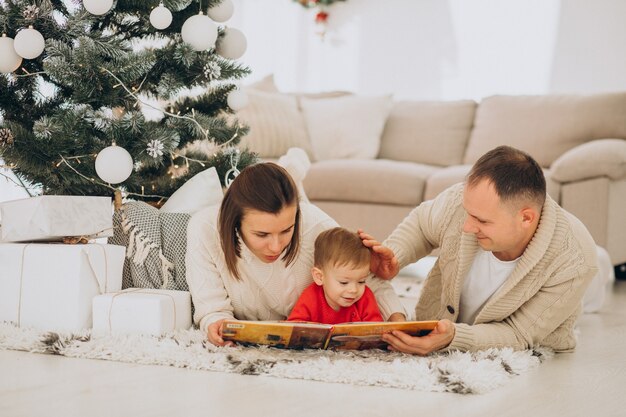 Famiglia con figlio piccolo a Natale da albero di Natale a casa