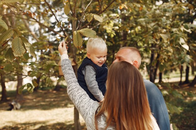 Famiglia con figlio piccolo in un parco in autunno