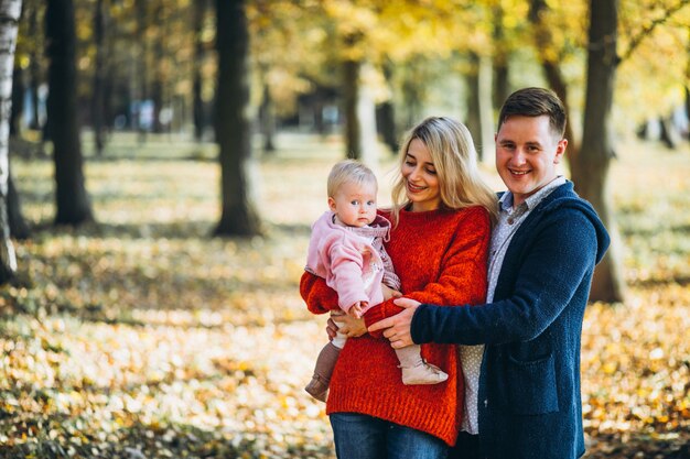 Famiglia con il bambino daugher in un parco di autunno