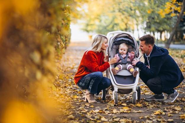 Famiglia con il daugher del bambino che cammina in un parco di autunno