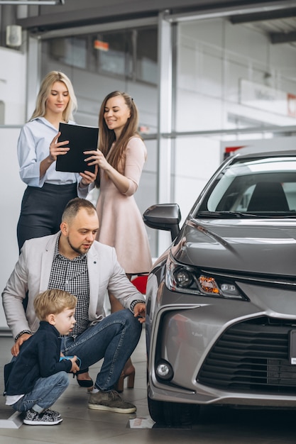 Famiglia con il figlio che sceglie un&#39;auto in uno showroom di auto