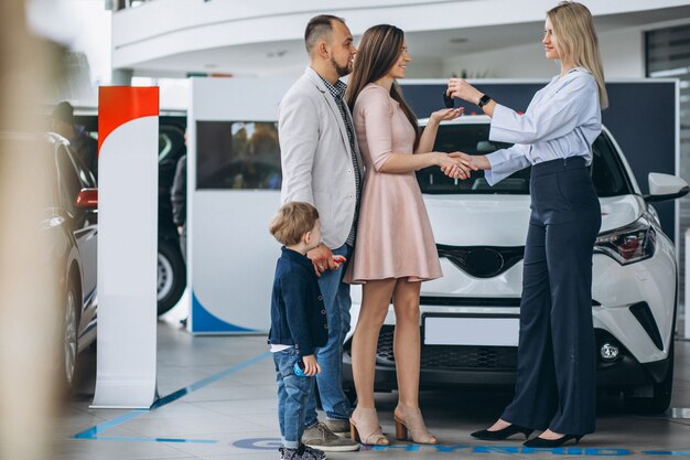 Famiglia con il figlio che sceglie un&#39;auto in uno showroom di auto