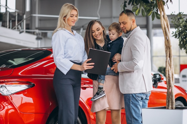 Famiglia con il figlio che sceglie un&#39;auto in uno showroom di auto