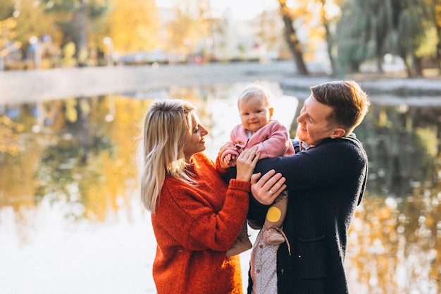 Famiglia con la figlia del bambino che cammina nel parco