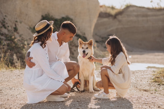 Famiglia con la figlia e il cane che camminano fuori