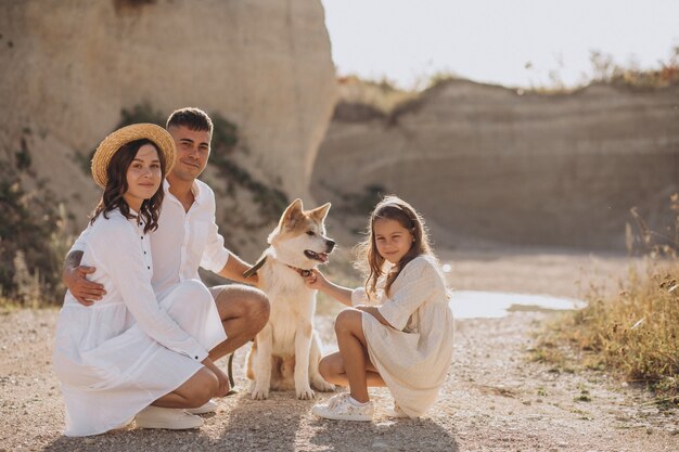 Famiglia con la figlia e il cane che camminano fuori