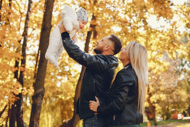 Famiglia con la figlia in un parco in autunno
