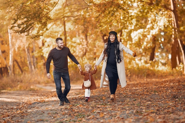 Famiglia con la piccola figlia in un parco di autunno