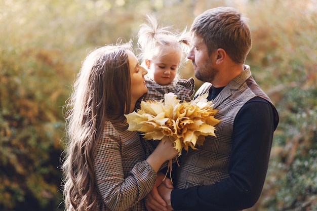 Famiglia con la piccola figlia in un parco di autunno