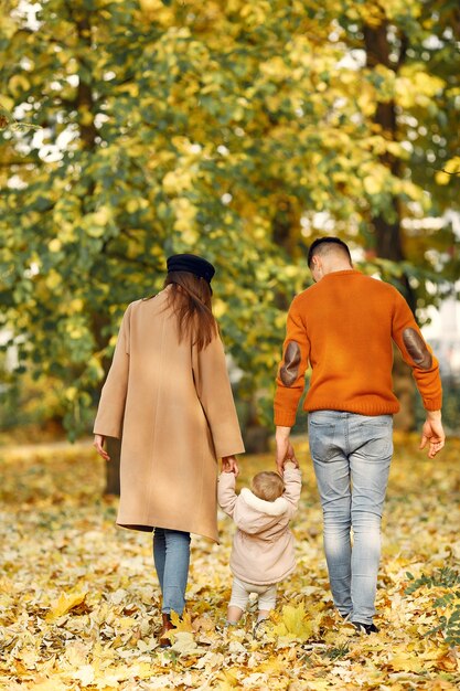 Famiglia con la piccola figlia in un parco di autunno