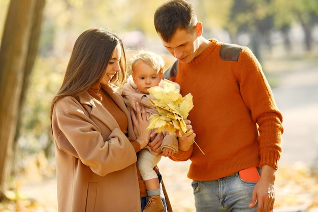 Famiglia con la piccola figlia in un parco di autunno