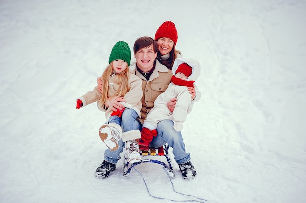 Famiglia con le figlie carine in un parco di inverno