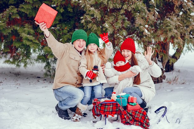 Famiglia con le figlie carine in un parco di inverno