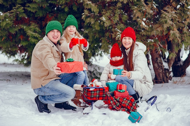 Famiglia con le figlie carine in un parco di inverno