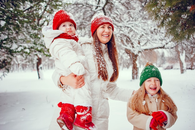 Famiglia con le figlie carine in un parco di inverno