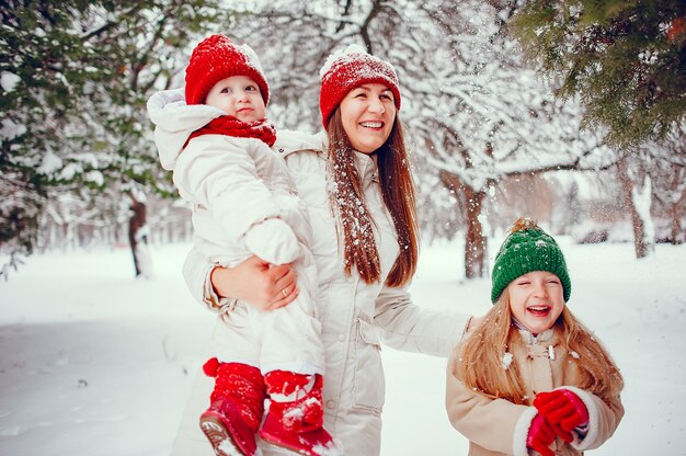 Famiglia con le figlie carine in un parco di inverno
