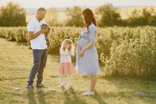 Famiglia con piccola figlia che trascorre del tempo insieme nel campo soleggiato