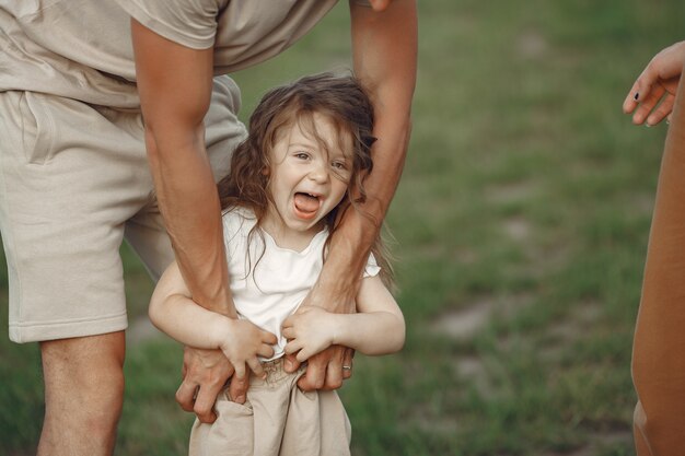 Famiglia con piccola figlia che trascorre del tempo insieme nel campo soleggiato