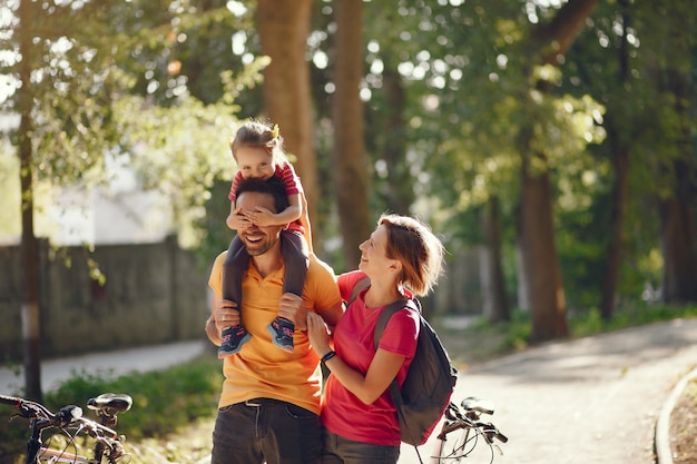 Famiglia con una bicicletta in un parco estivo