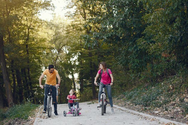 Famiglia con una bicicletta in un parco estivo