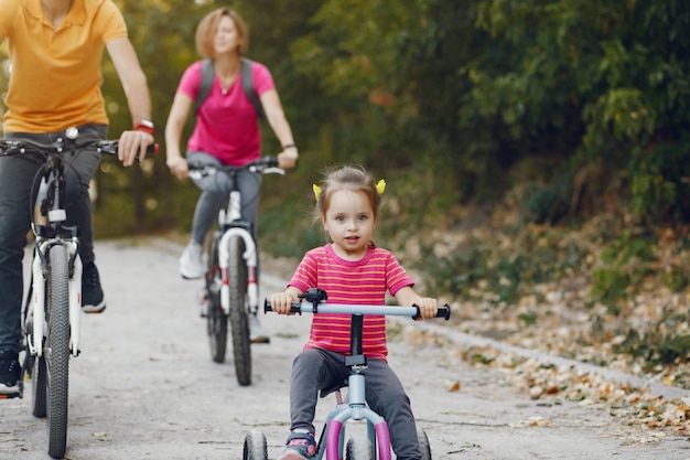 Famiglia con una bicicletta in un parco estivo