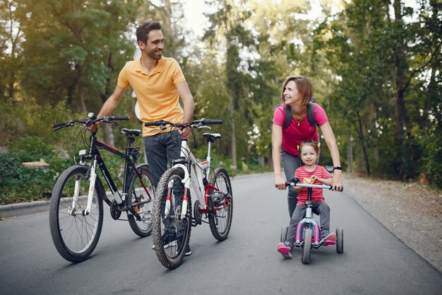 Famiglia con una bicicletta in un parco estivo