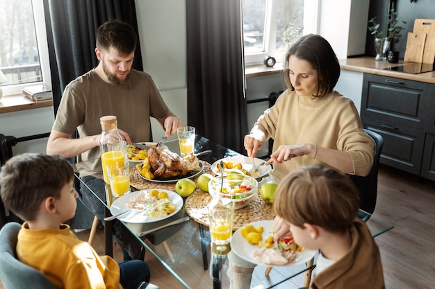Famiglia cristiana del colpo medio che mangia insieme