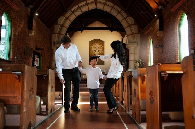 Famiglia cristiana felice del colpo pieno in chiesa