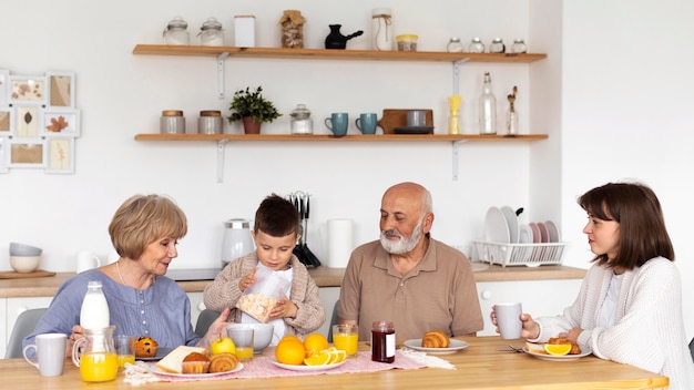 Famiglia del colpo medio che si siede al tavolo