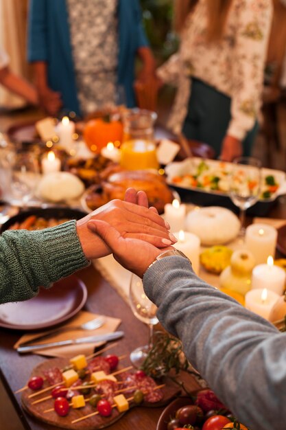 Famiglia del primo piano che si tiene per mano a cena