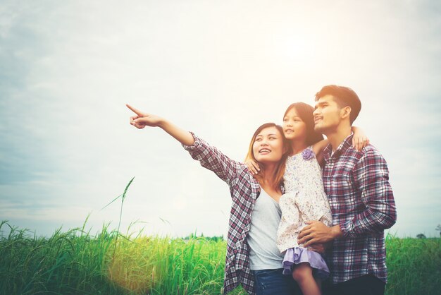 Famiglia di madre, padre e figlio sul prato, il papà che trasportano il d