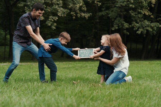 Famiglia di quattro membri che si diverte giocando nel parco