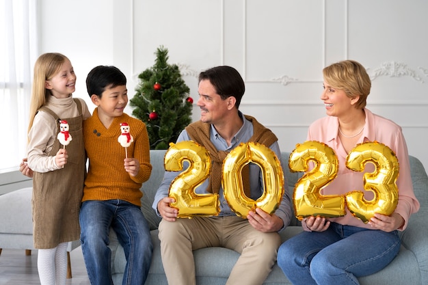 Famiglia di quattro persone che festeggiano il capodanno a casa insieme