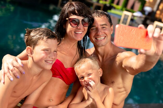 Famiglia di quattro persone che si gode una giornata in piscina insieme