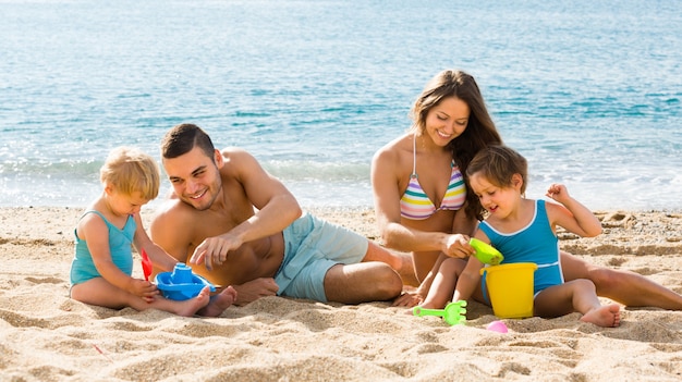 Famiglia di quattro persone in spiaggia