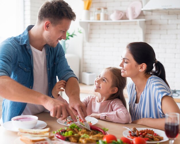 Famiglia di vista laterale che mangia insieme