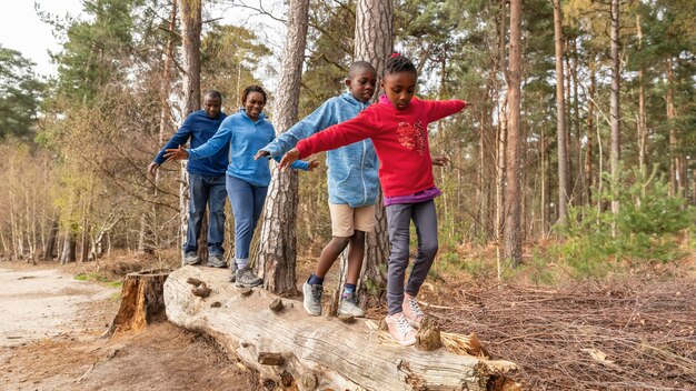 Famiglia divertendosi su un albero caduto