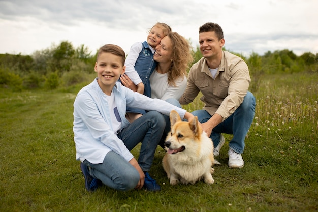 Famiglia felice a tutto campo con un cane adorabile