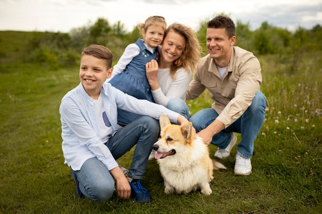 Famiglia felice a tutto campo con un cane carino