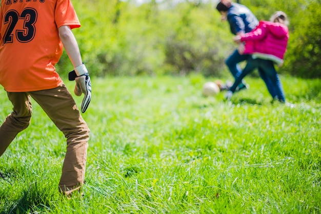 Famiglia felice che gioca con palla nel parco