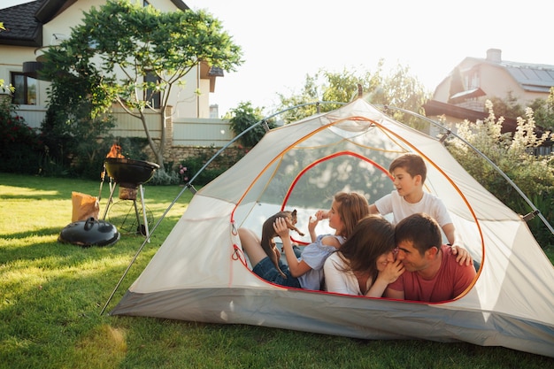 Famiglia felice che gode in tenda della camma al parco