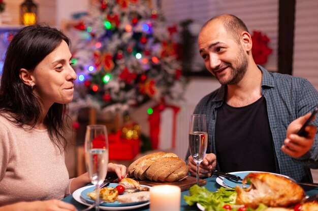 Famiglia felice che mangia una cena deliziosa seduta al tavolo da pranzo