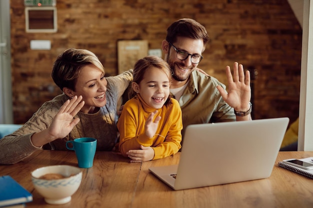 Famiglia felice che saluta durante la videochiamata a casa