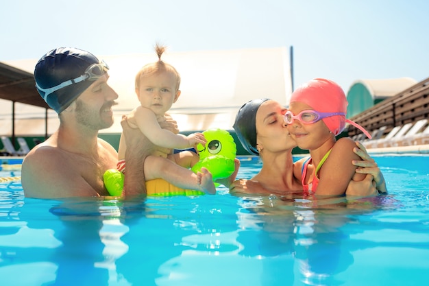 Famiglia felice che si diverte a bordo piscina