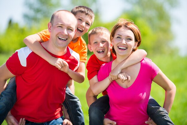 Famiglia felice con due bambini sulla natura - concetto di felicità