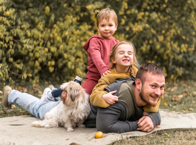 Famiglia felice con simpatico cane all'aperto